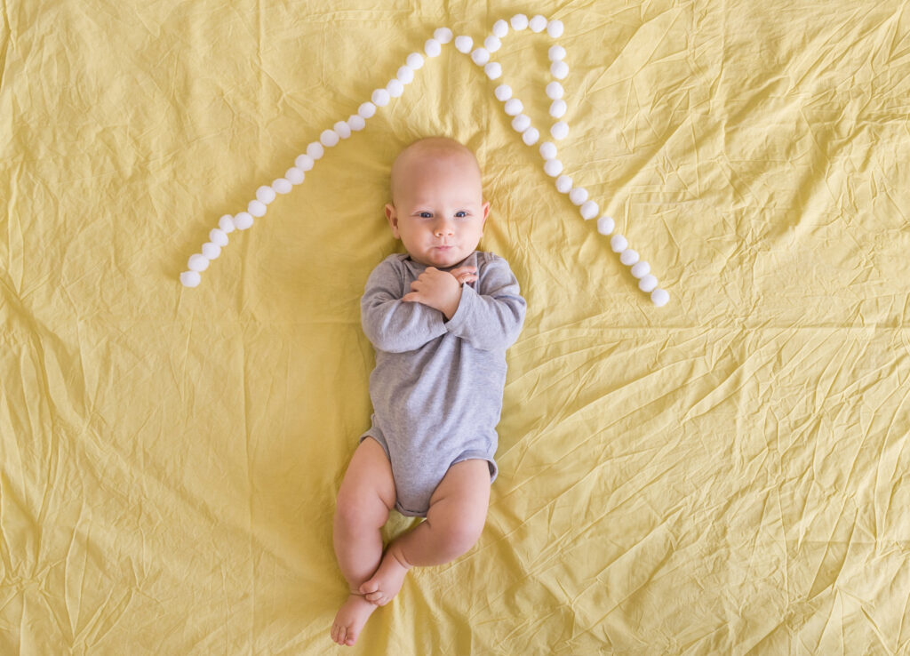 beautiful infant child under house roof made of cotton balls in bed